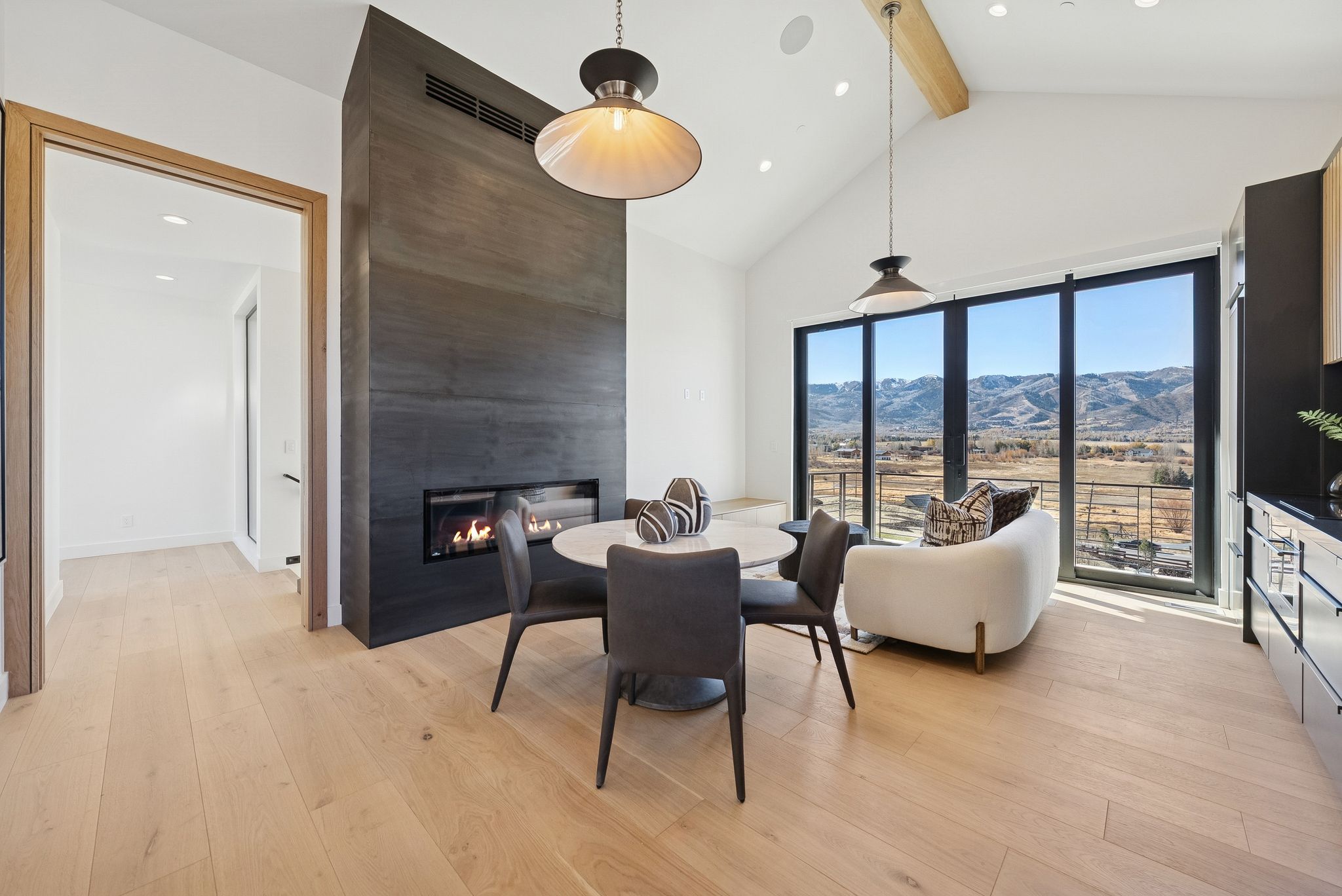 Dining space with light wood-style flooring, a mountain view, beam ceiling, a fireplace, and recessed lighting
