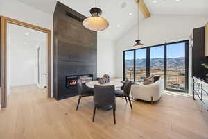 Dining space with light wood-style flooring, a mountain view, beam ceiling, a fireplace, and recessed lighting