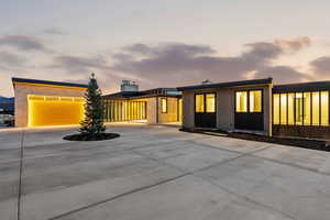 View of front of property with concrete driveway, a chimney, and a garage