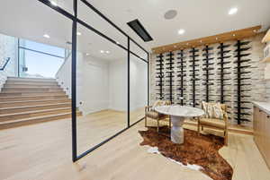 Wine cellar featuring light wood finished floors