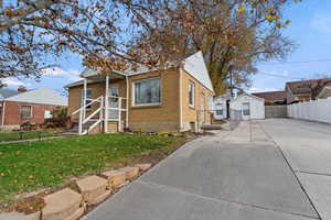 Bungalow with brick siding, an outdoor structure, and driveway