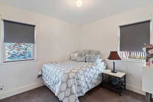 Carpeted bedroom featuring baseboards and a textured ceiling