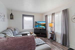 Living area with plenty of natural light, a textured ceiling, and wood finished floors