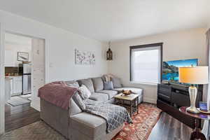 Living area featuring dark wood-style flooring and a textured ceiling