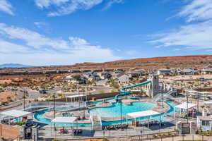 Community pool featuring a water slide, a residential view, a mountain view, and a patio area