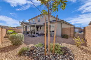 Rear view of property with a fenced backyard, a patio, stucco siding, an outdoor living space, and a tiled roof