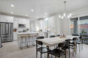 Dining space featuring light wood-type flooring, recessed lighting, and a chandelier
