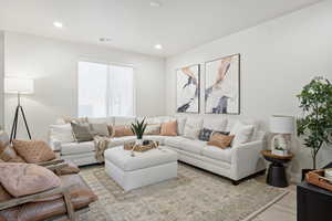 Living room with light wood-type flooring and recessed lighting