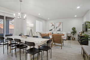 Dining space featuring light wood-type flooring, recessed lighting, and a chandelier
