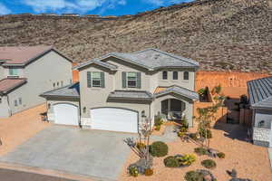 View of front of home featuring stucco siding, a tile roof, and concrete driveway