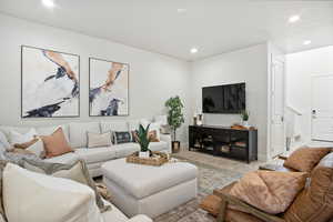 Living area with wood finished floors and recessed lighting
