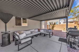Fenced backyard with an outdoor living space, a patio area, and grilling area
