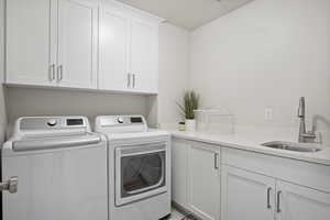 Washroom featuring cabinet space and separate washer and dryer