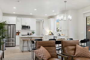 Kitchen featuring healthy amount of natural light, stainless steel appliances, a center island, a breakfast bar, and recessed lighting