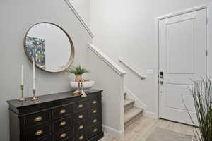 Foyer featuring light wood-type flooring and stairs