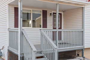 Doorway to property with covered porch