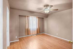 Unfurnished room featuring light wood-type flooring, ceiling fan, and a textured ceiling