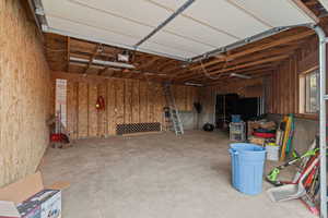 Garage featuring wooden walls and a garage door opener