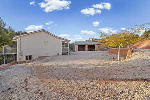 Rear view of house with a garage and an outbuilding