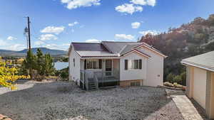 View of front of home with a mountain view, a metal roof, and a porch