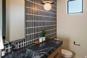 Half bathroom with vanity and toilet