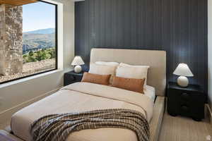Bedroom with wallpapered walls and a mountain view