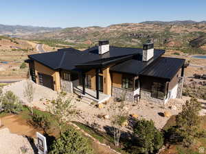 View of front facade featuring stone siding, a metal roof, a standing seam roof, and a mountain view