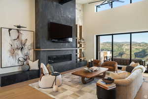 Living area with wood finished floors, a fireplace, and a high ceiling