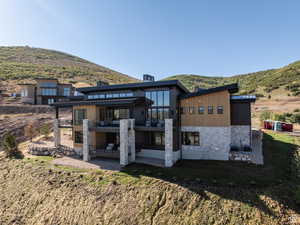 Rear view of property with a patio, a metal roof, a standing seam roof, and a mountain view