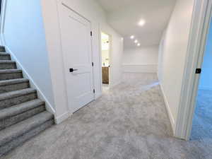 Corridor featuring stairway, light carpet, and recessed lighting