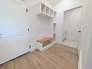 Mudroom with light wood-style floors and baseboards