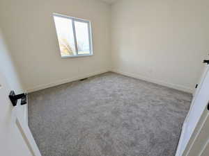 Empty room with carpet flooring and baseboards