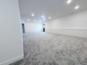 Carpeted spare room featuring recessed lighting and baseboards