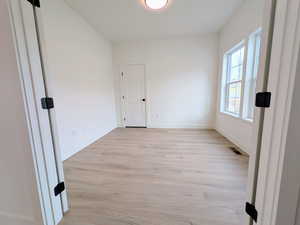 Unfurnished room with light wood-style floors and baseboards