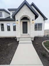Doorway to property featuring stone siding and board and batten siding