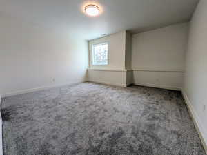 Empty room with carpet floors and baseboards