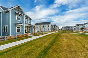 View of home's community with a lawn, a porch, and a residential view