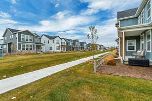 View of green lawn featuring a residential view and covered porch