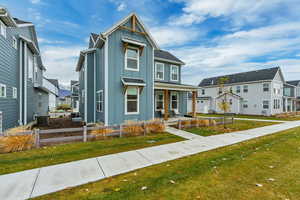 View of front of property with board and batten siding, a porch, a residential view, and a front yard