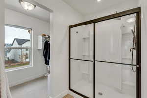 Bathroom featuring a stall shower and light carpet