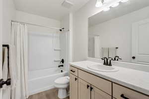 Full bathroom featuring shower / bath combo, vanity, and light wood-style flooring
