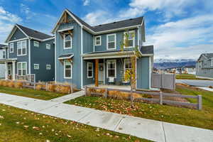 View of front facade featuring board and batten siding, a mountain view, a residential view, covered porch, and roof with shingles