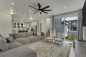 Living area with recessed lighting, stairs, a ceiling fan, and light wood-type flooring