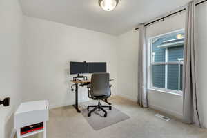 Office space featuring light colored carpet and baseboards