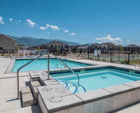 Community pool with a patio, a residential view, and a hot tub