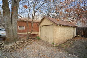 View of property exterior with a shed and brick siding