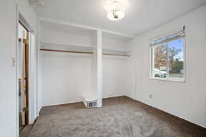 Unfurnished bedroom with multiple closets and carpet