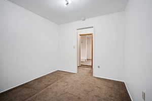 Empty room with carpet floors and baseboards