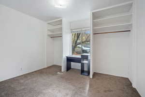 Unfurnished bedroom featuring carpet and multiple closets