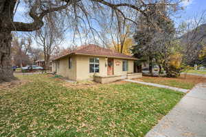 Bungalow-style house featuring a front yard and concrete block siding